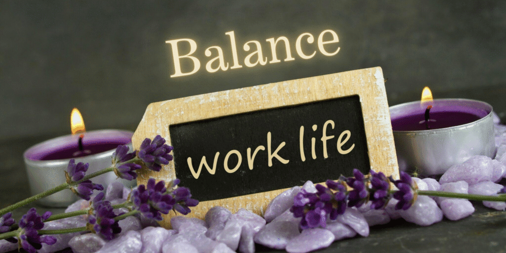 A small chalkboard with the words “work life” surrounded by purple candles and lavender flowers, symbolizing the Principle of Balance.