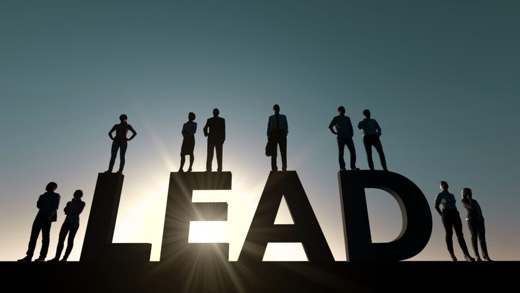 ELITE LEAD PERFORM Silhouettes of professionals standing on large letters spelling LEAD, representing leadership and growth.