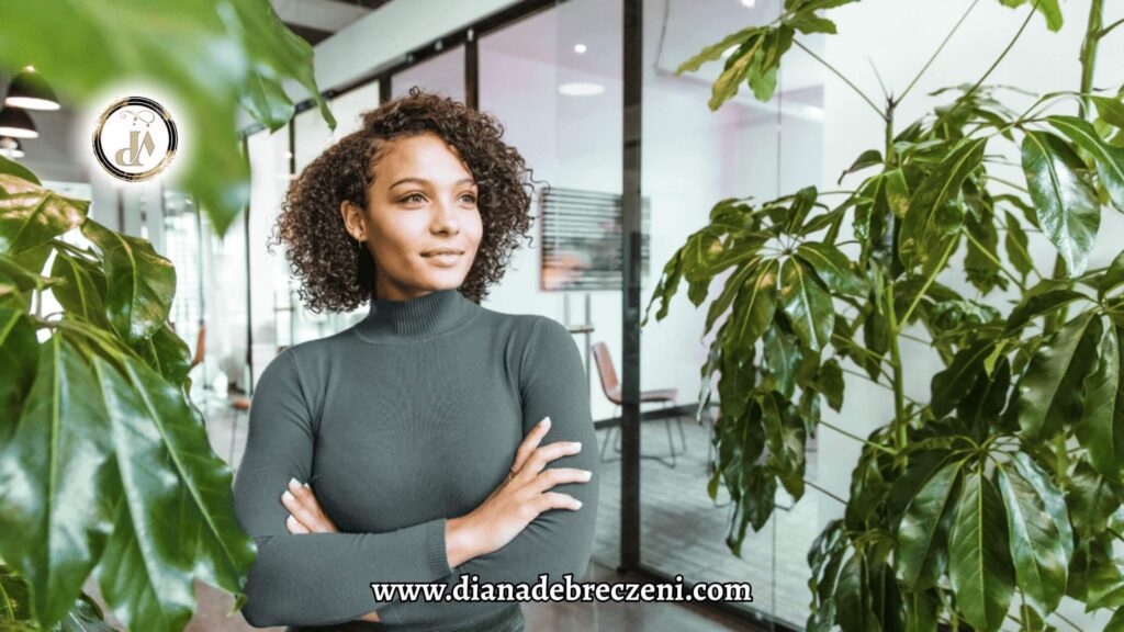 A confident woman standing near green plants in a bright office, symbolizing balance and calm used in focus improvement techniques