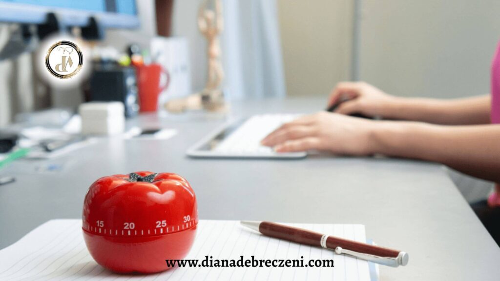 Pomodoro timer on a desk next to a notebook and pen, symbolizing time management and focus improvement techniques.